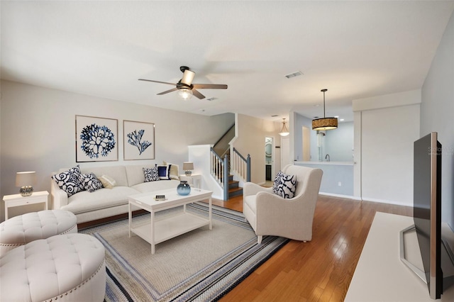 living room featuring ceiling fan and hardwood / wood-style flooring