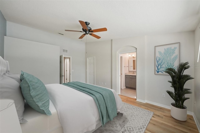 bedroom featuring connected bathroom, ceiling fan, and light hardwood / wood-style flooring