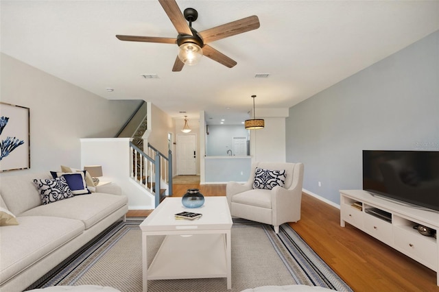 living room featuring hardwood / wood-style floors and ceiling fan