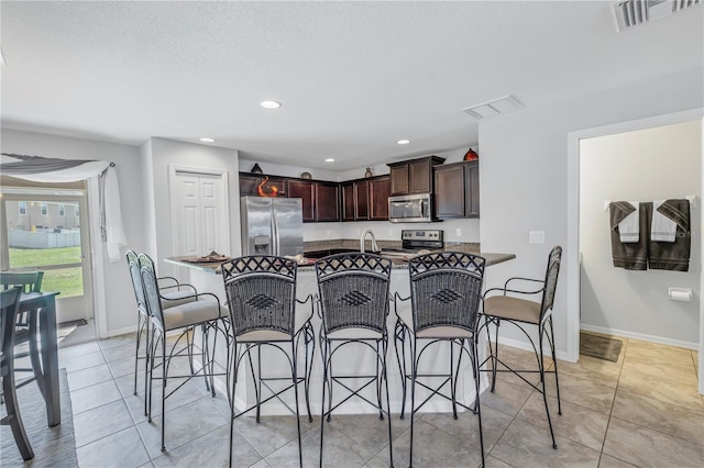 kitchen featuring kitchen peninsula, stainless steel appliances, and a breakfast bar area