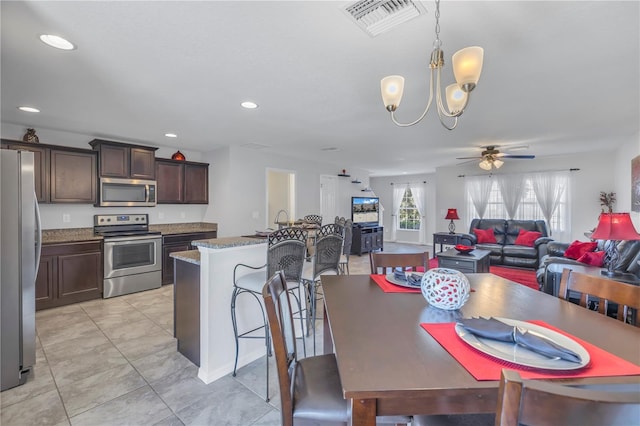 dining space featuring ceiling fan with notable chandelier and light tile patterned flooring