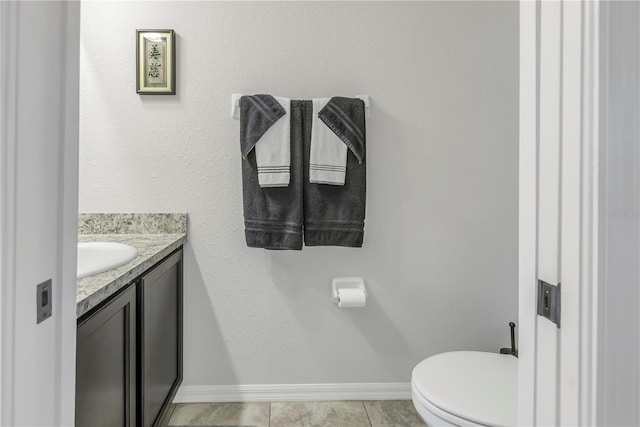 bathroom featuring tile patterned flooring, vanity, and toilet