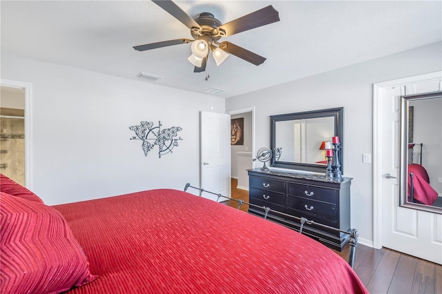 bedroom featuring connected bathroom, ceiling fan, and dark wood-type flooring