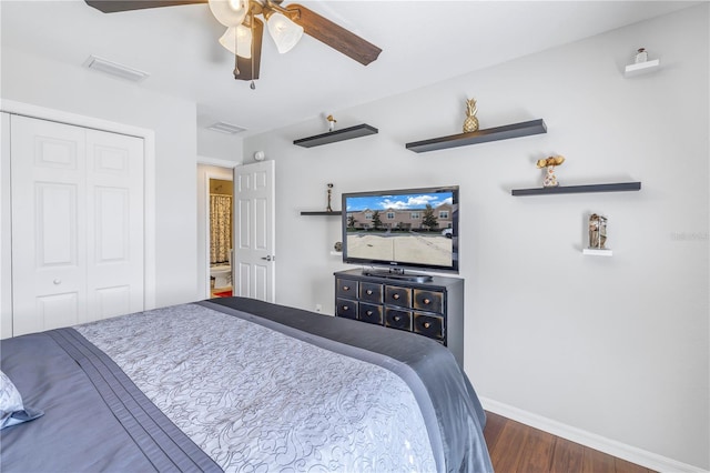 bedroom with ceiling fan, dark wood-type flooring, and a closet