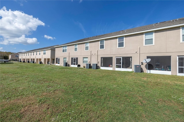 back of property featuring a yard and cooling unit