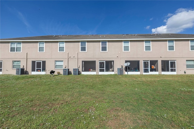 back of property featuring a lawn and central air condition unit