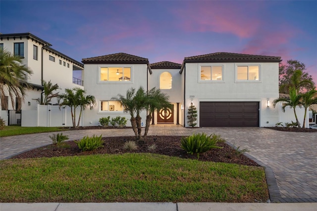 mediterranean / spanish-style home featuring a garage and a yard