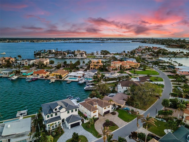 aerial view at dusk featuring a water view