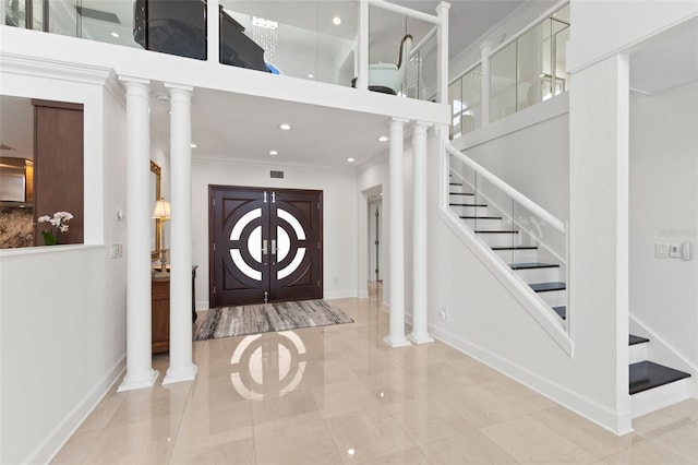 entryway featuring tile patterned floors, ornamental molding, and french doors