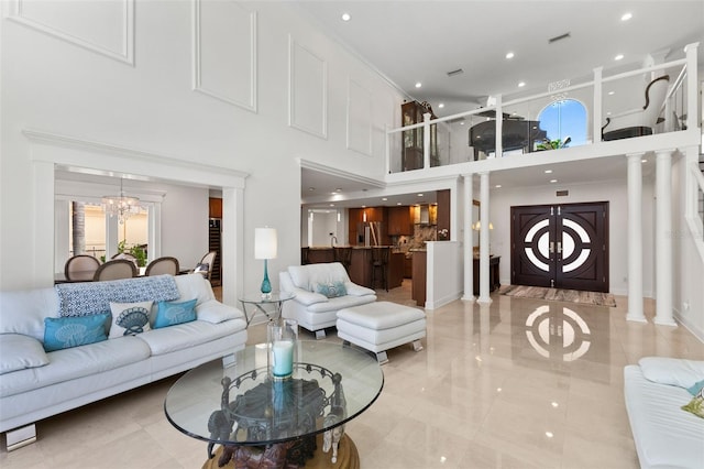 living room featuring a towering ceiling and a notable chandelier