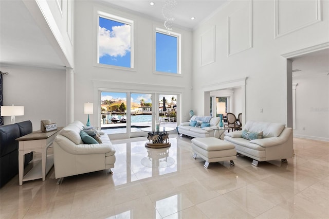 living room with crown molding, a towering ceiling, and light tile patterned floors