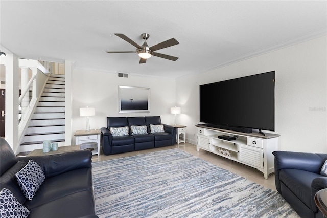 living room with ceiling fan and ornamental molding