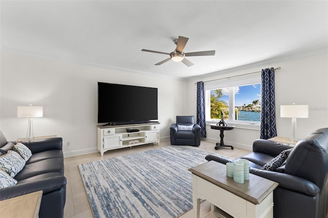 living room with ceiling fan, light tile patterned floors, and crown molding