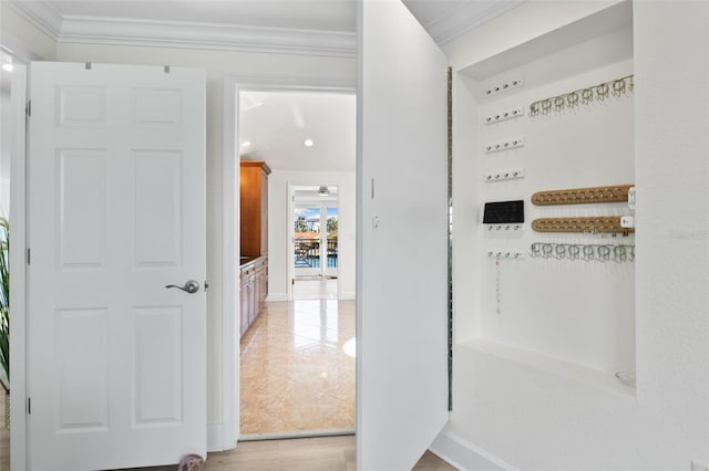 hall with ornamental molding and light wood-type flooring