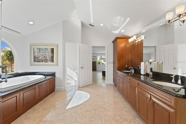 bathroom featuring a bathing tub, vanity, a healthy amount of sunlight, and lofted ceiling