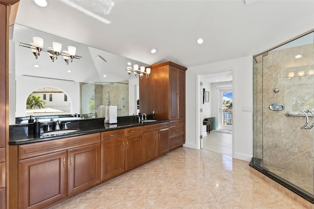 bathroom featuring vanity, a shower with shower door, and an inviting chandelier