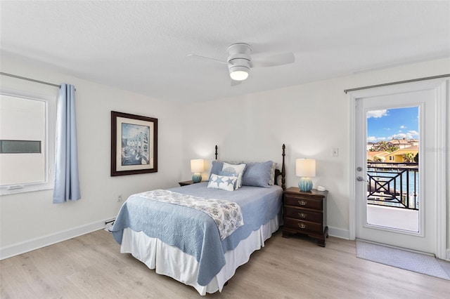 bedroom featuring access to exterior, ceiling fan, light hardwood / wood-style floors, and a textured ceiling