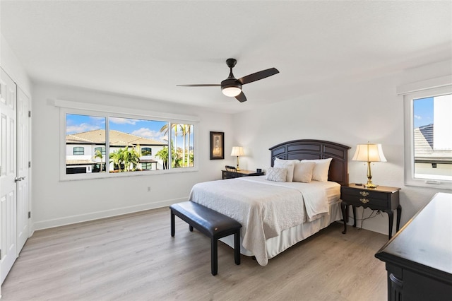 bedroom with light hardwood / wood-style flooring, multiple windows, and ceiling fan