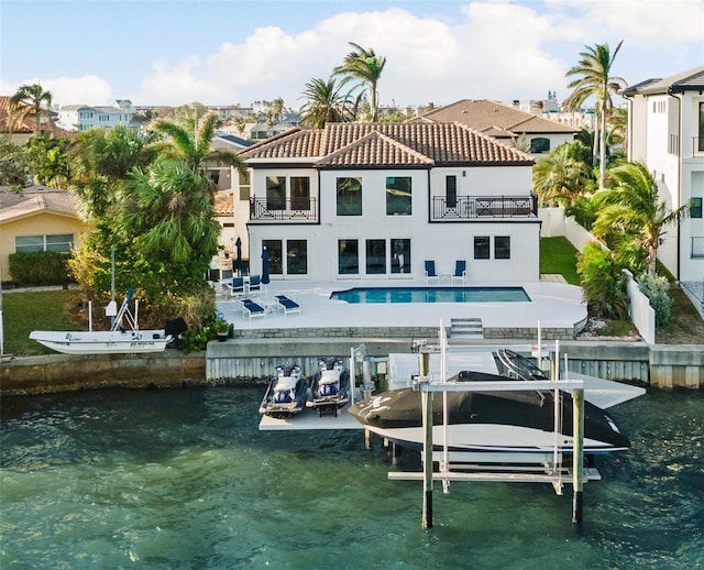 back of property featuring a balcony, a patio, and a water view