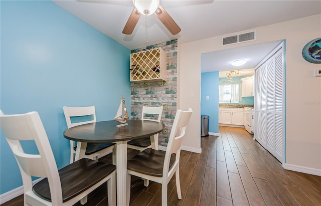 dining space with dark wood-type flooring, sink, and ceiling fan