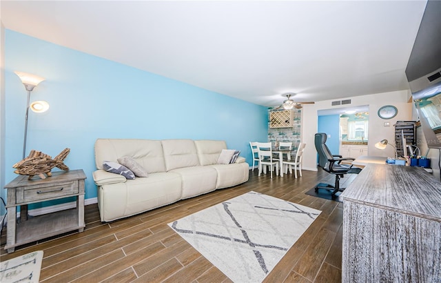 living room featuring dark wood-type flooring and ceiling fan