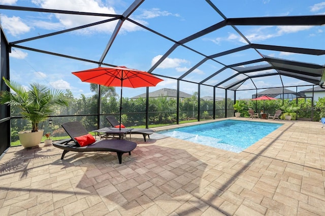 view of swimming pool featuring a patio area, glass enclosure, and a mountain view