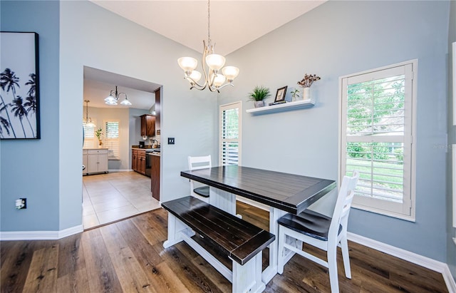 3647 Muirfield Ct, New Port Richey, FL 34655 - dining room with a chandelier, vaulted ceiling, plenty of natural light, and baseboards
