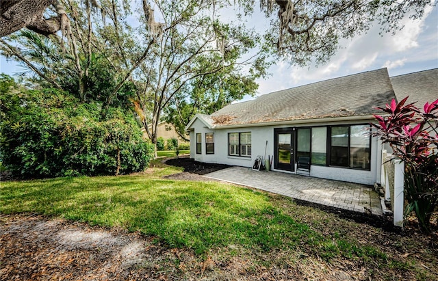 3647 Muirfield Ct, New Port Richey, FL 34655 - rear view of house with a patio, a yard, stucco siding, and roof with shingles