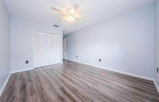 3647 Muirfield Ct, New Port Richey, FL 34655 - unfurnished bedroom featuring wood finished floors, a closet, baseboards, and a ceiling fan