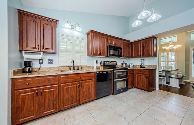 kitchen featuring black appliances, a notable chandelier, a wealth of natural light, hanging light fixtures, and lofted ceiling