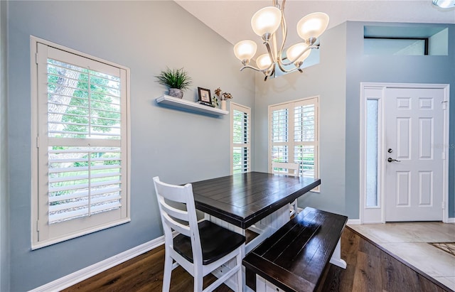 3647 Muirfield Ct, New Port Richey, FL 34655 - dining area featuring a chandelier, wood finished floors, lofted ceiling, and baseboards