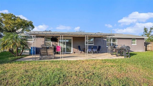 rear view of property featuring a lawn and a patio