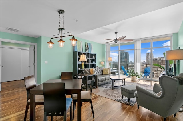 dining area featuring ceiling fan, hardwood / wood-style floors, and expansive windows