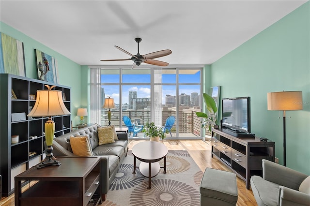 living room with light wood-type flooring, expansive windows, and plenty of natural light