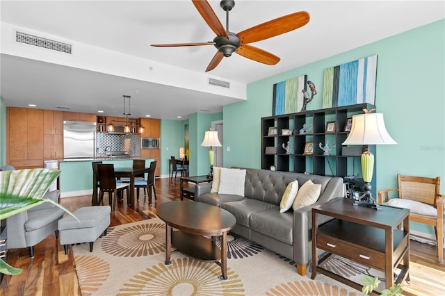 living room featuring ceiling fan and light hardwood / wood-style floors