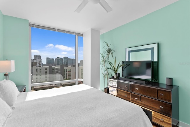 bedroom featuring ceiling fan and floor to ceiling windows