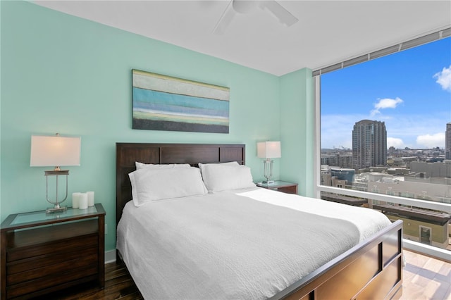 bedroom featuring floor to ceiling windows, ceiling fan, and dark wood-type flooring