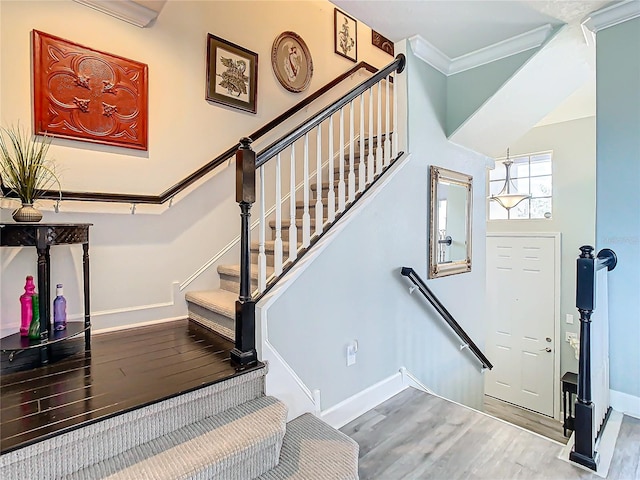 stairway with hardwood / wood-style floors and crown molding