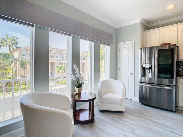 interior space featuring light hardwood / wood-style floors, a healthy amount of sunlight, and crown molding