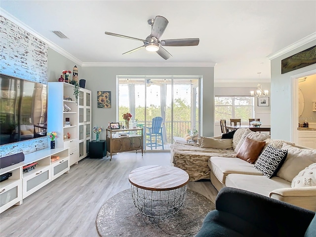 living room with ceiling fan with notable chandelier, light hardwood / wood-style flooring, and ornamental molding