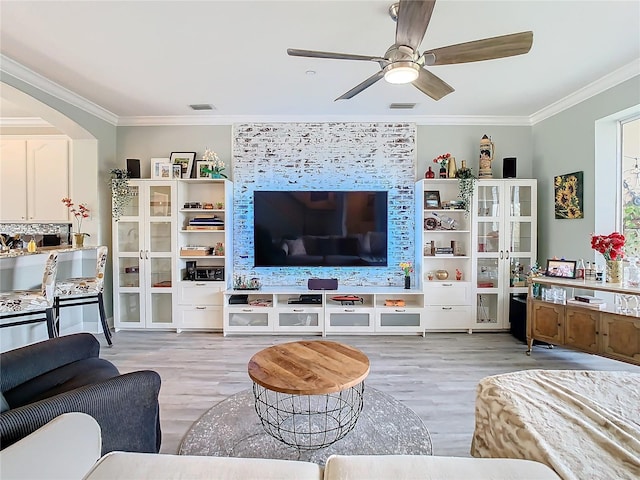 living room with light wood-type flooring, ceiling fan, and crown molding