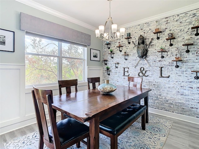 dining room with light wood-type flooring, crown molding, and an inviting chandelier