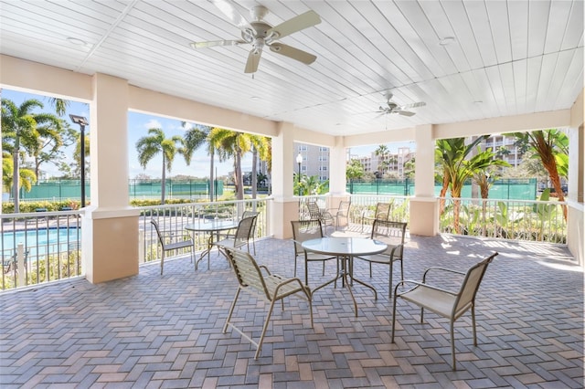 view of patio with ceiling fan and a water view