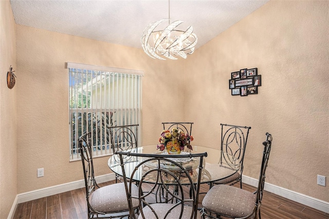 dining space featuring dark hardwood / wood-style flooring, an inviting chandelier, and a textured ceiling