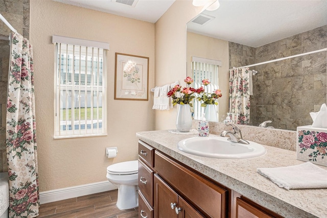 bathroom with toilet, vanity, hardwood / wood-style floors, and curtained shower