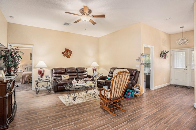 living room with a textured ceiling, hardwood / wood-style flooring, and ceiling fan