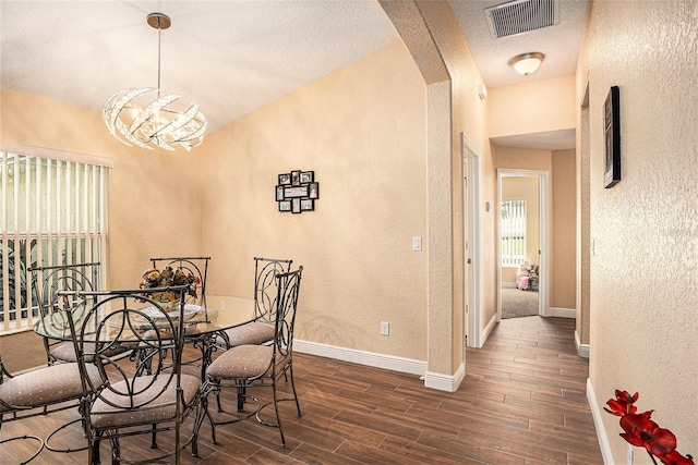 dining room featuring dark wood-type flooring and a notable chandelier