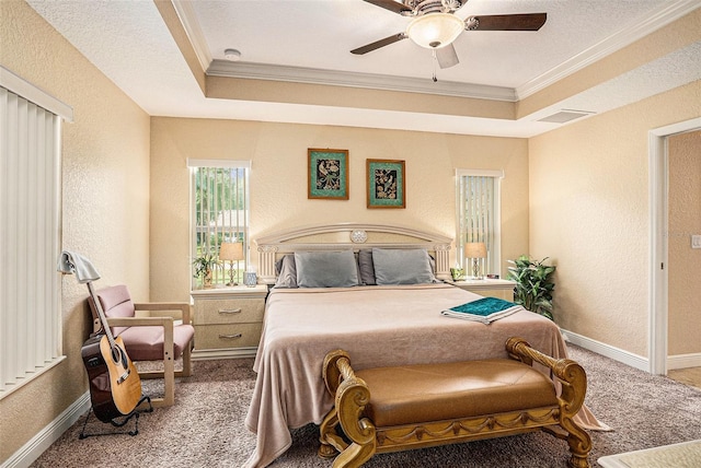 bedroom featuring ceiling fan, a raised ceiling, crown molding, and carpet