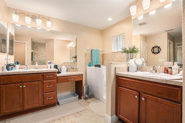 bathroom featuring a shower, vanity, and a textured ceiling