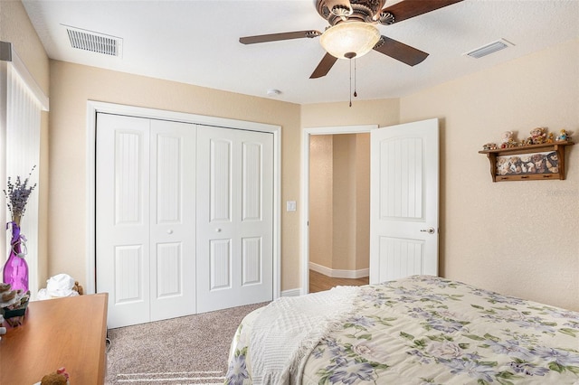 carpeted bedroom featuring ceiling fan and a closet